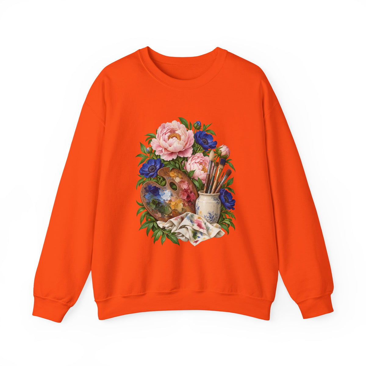 The Colors She Kept crewneck sweatshirt, a paint-covered artist palette beside a cream ceramic jar of brushes with pink peonies and deep blue flowers, image 6 of 28