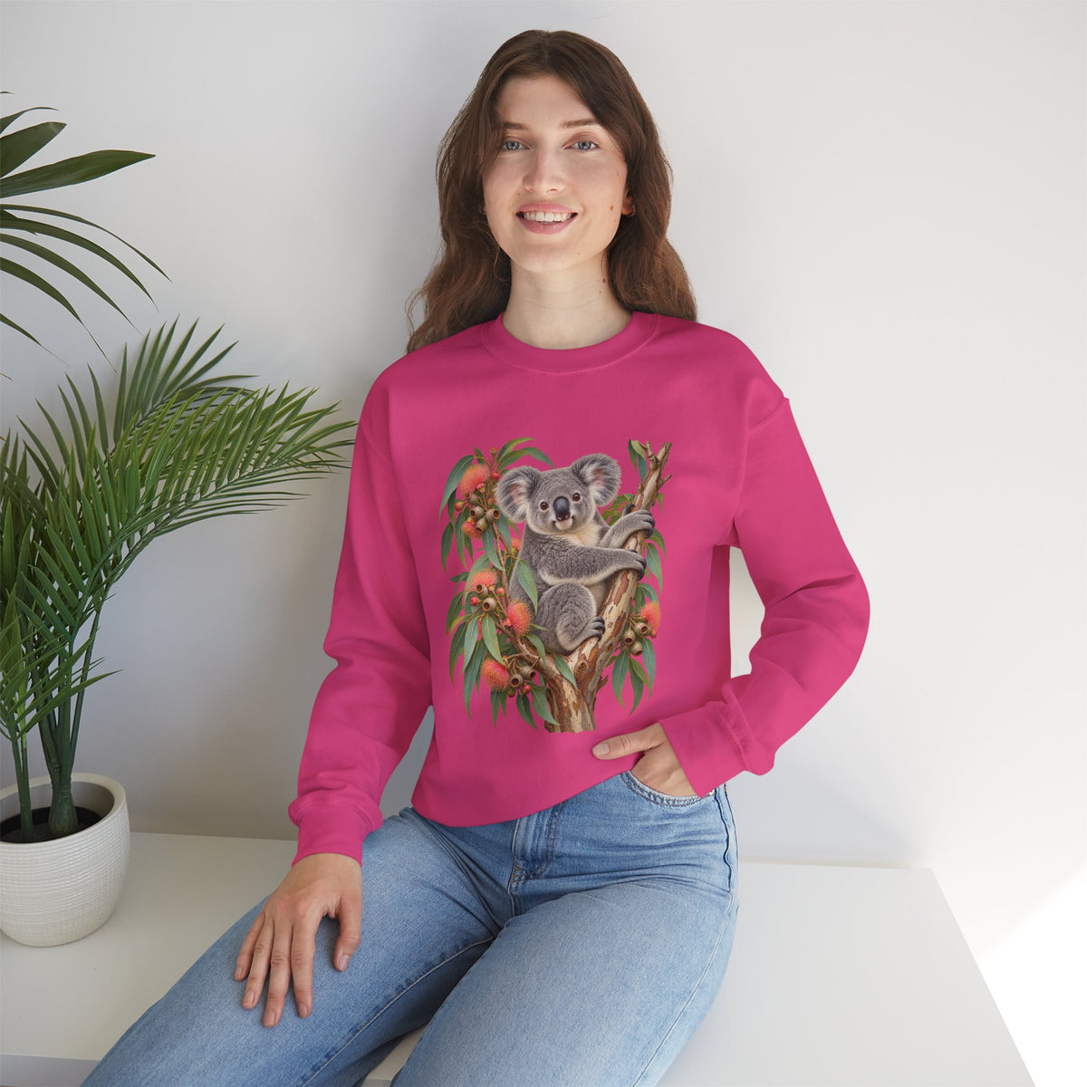 Booked for the Afternoon sweatshirt — a grey koala resting among eucalyptus leaves and coral-pink blossoms, on a unisex crewneck