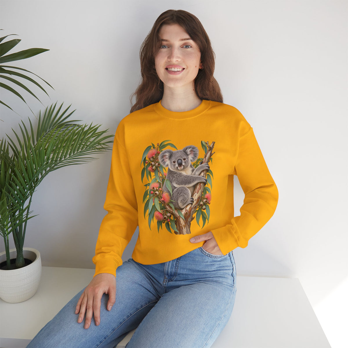 Booked for the Afternoon sweatshirt — a grey koala resting among eucalyptus leaves and coral-pink blossoms, on a unisex crewneck