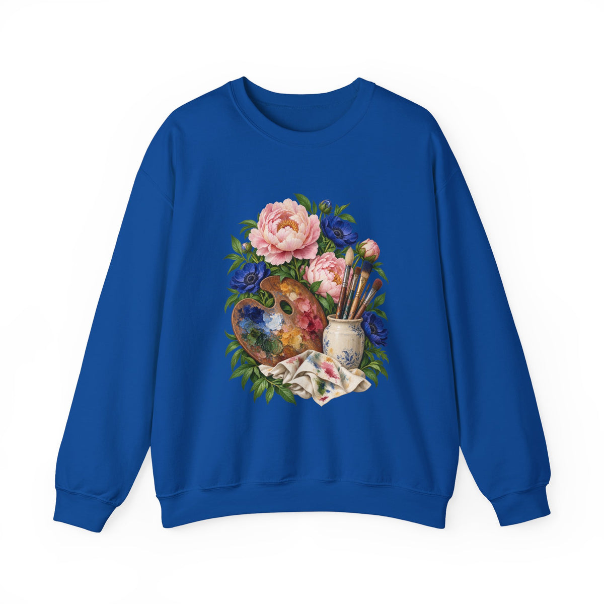 The Colors She Kept crewneck sweatshirt, a paint-covered artist palette beside a cream ceramic jar of brushes with pink peonies and deep blue flowers, image 7 of 28
