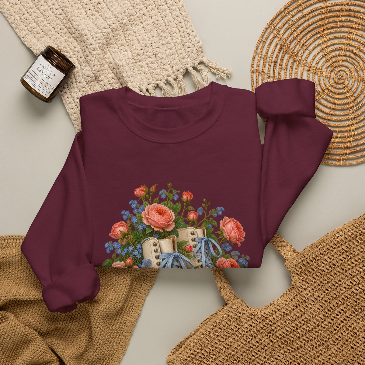 She Still Rolls crewneck sweatshirt, cream roller skates with blue laces and dusty pink wheels among coral roses, small blue flowers and trailing greenery, image 10 of 21