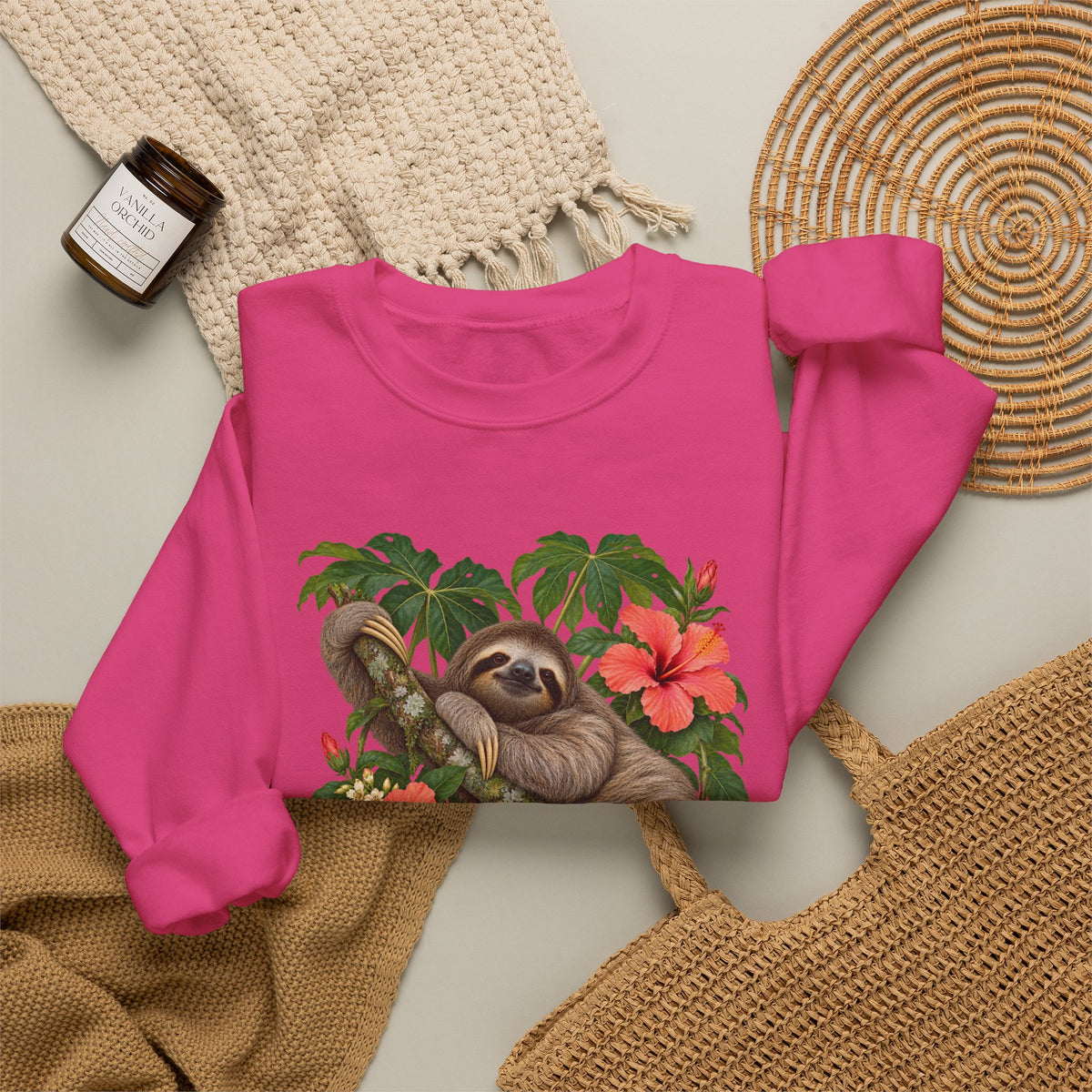 Taking My Sweet Time sweatshirt — a sloth resting on a mossy branch among coral hibiscus, cream blossoms and tropical leaves, on a unisex crewneck