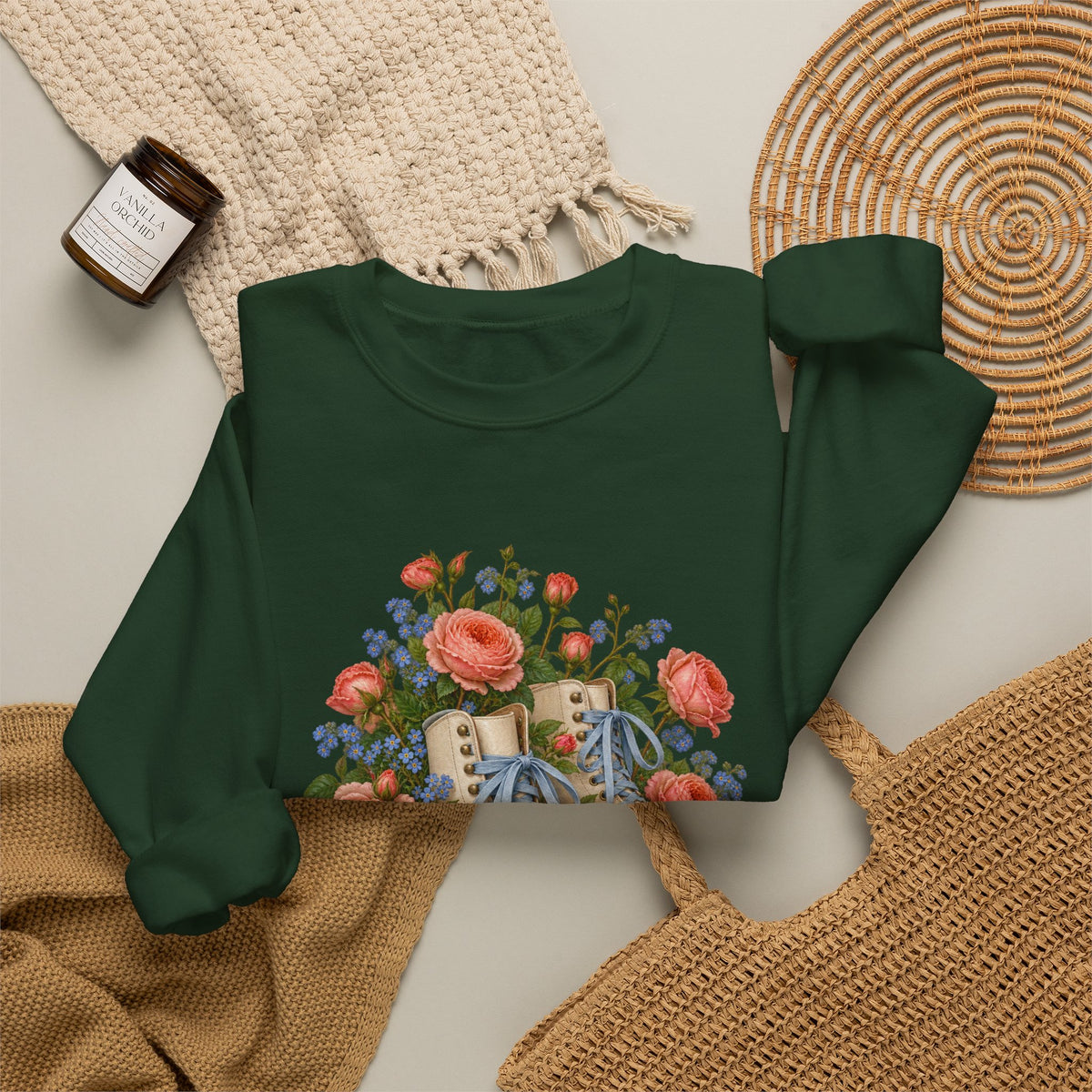 She Still Rolls crewneck sweatshirt, cream roller skates with blue laces and dusty pink wheels among coral roses, small blue flowers and trailing greenery, image 17 of 21