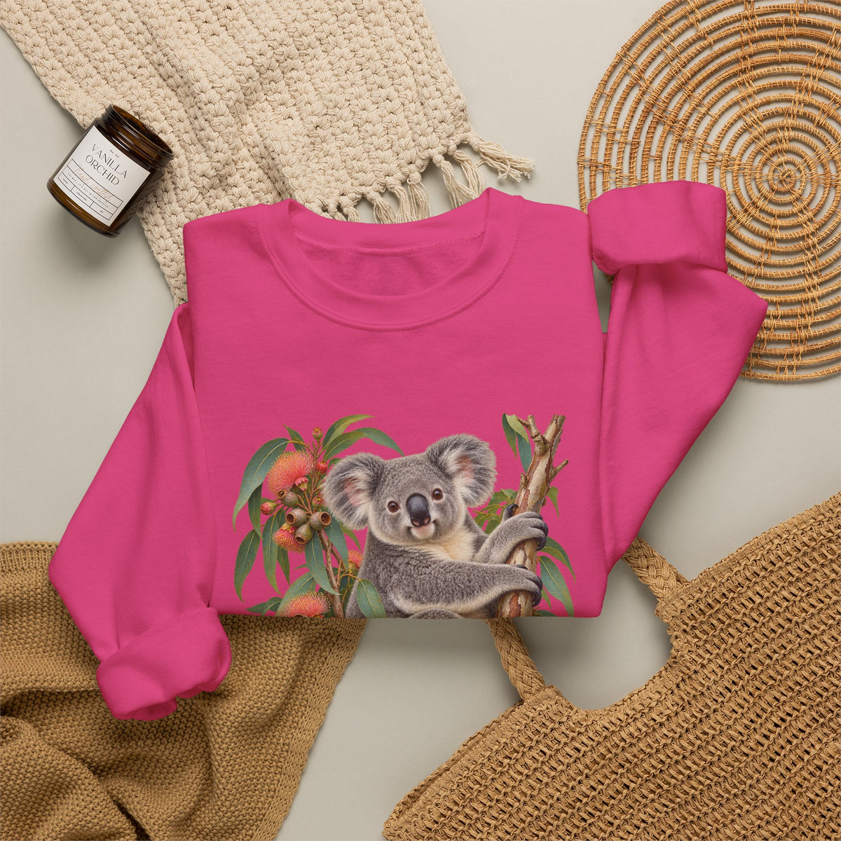Booked for the Afternoon sweatshirt — a grey koala resting among eucalyptus leaves and coral-pink blossoms, on a unisex crewneck