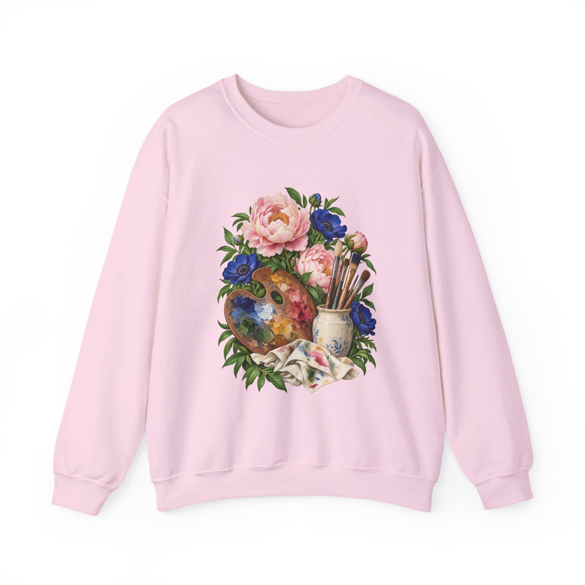 The Colors She Kept crewneck sweatshirt, a paint-covered artist palette beside a cream ceramic jar of brushes with pink peonies and deep blue flowers, image 5 of 28