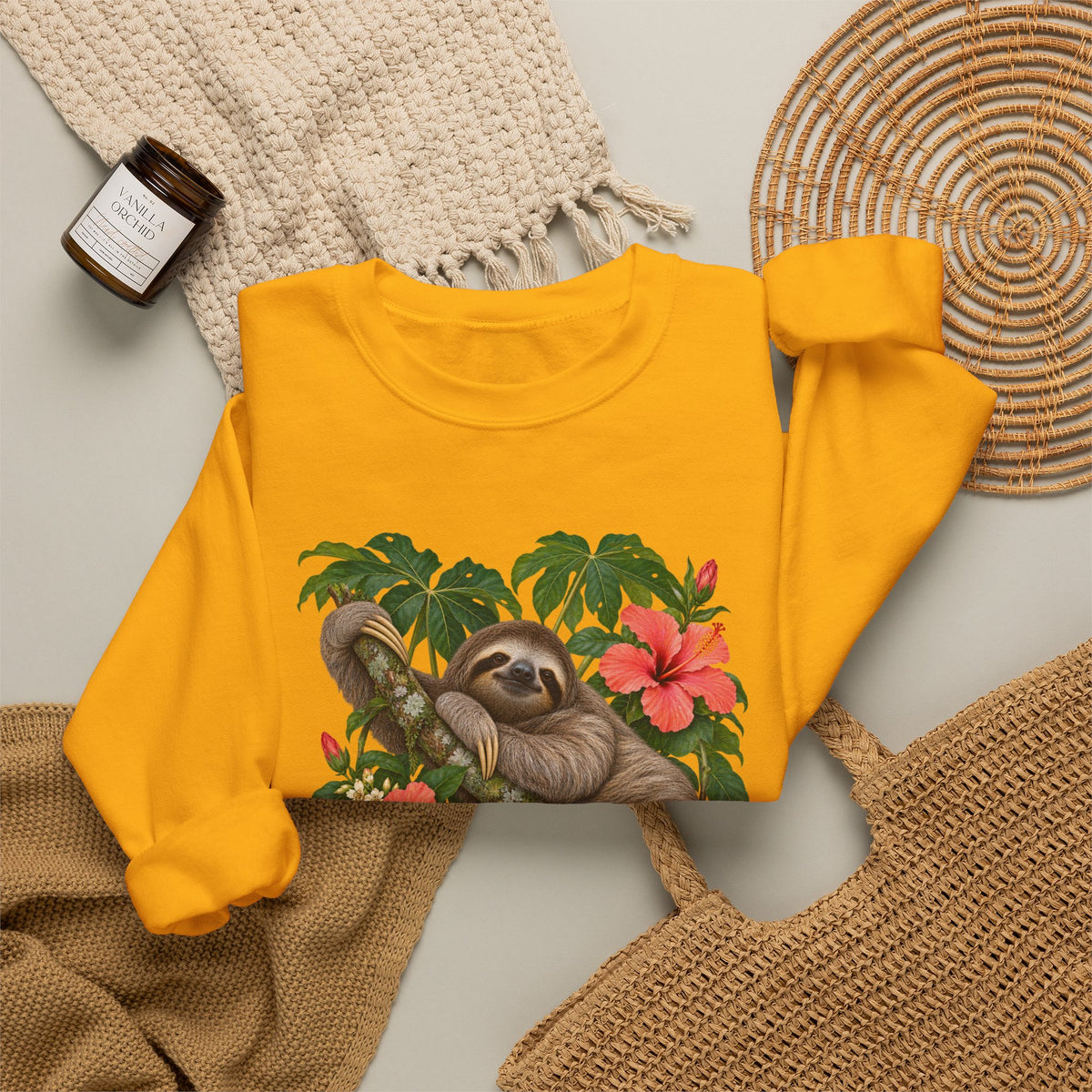 Taking My Sweet Time sweatshirt — a sloth resting on a mossy branch among coral hibiscus, cream blossoms and tropical leaves, on a unisex crewneck
