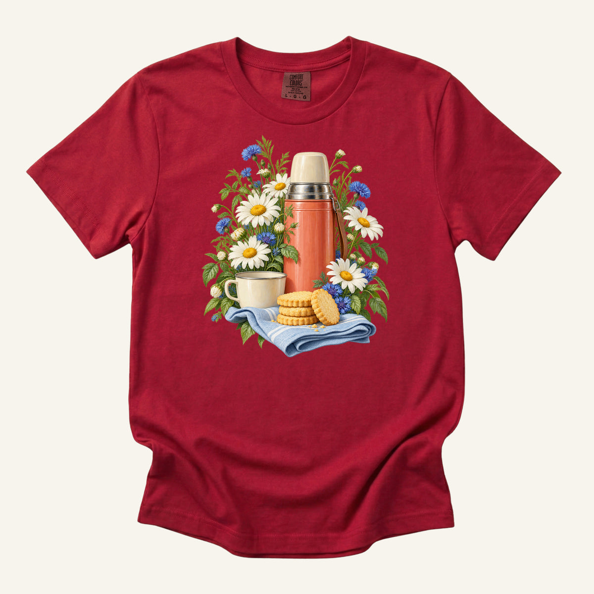 A Little Further, Then Tea t-shirt in Red, a true warm red — vintage tea flask among white daisies with a cup and biscuits on folded cloth, garment-dyed Comfort Colors 1717 tee