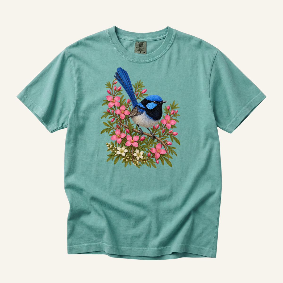 Small blue and black bird with an upright tail among pink blossoms and cream flowers, printed on a Chalky Mint green Comfort Colors 1717 unisex t-shirt