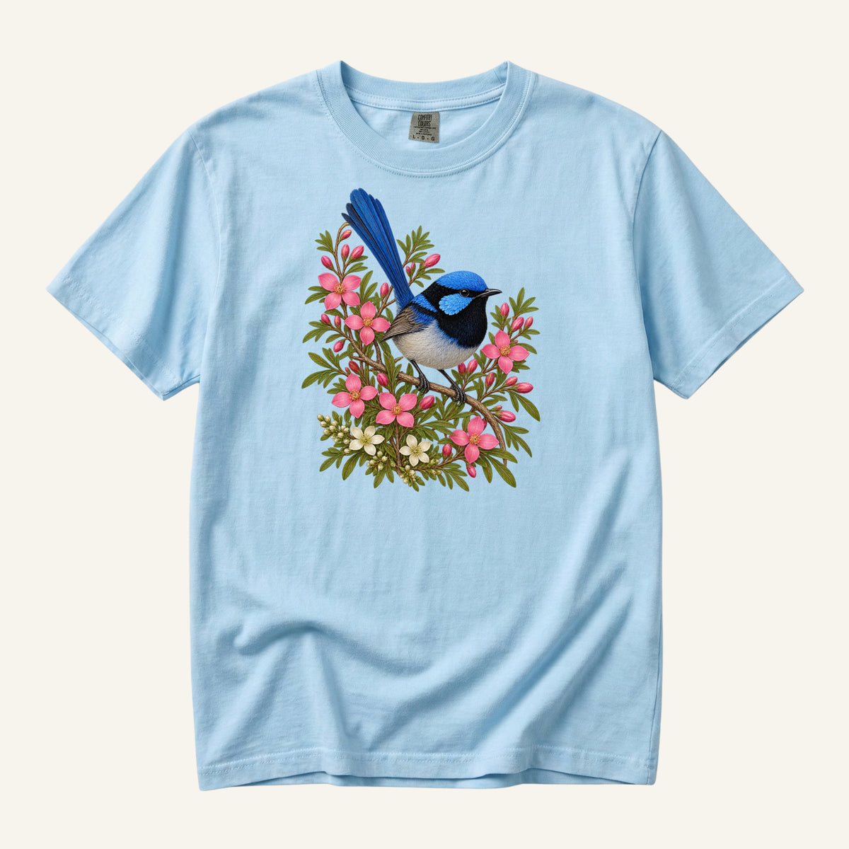 Small blue and black bird with an upright tail among pink blossoms and cream flowers, printed on a Chambray blue Comfort Colors 1717 unisex t-shirt