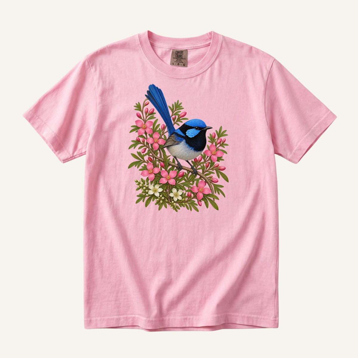 Small blue and black bird with an upright tail among pink blossoms and cream flowers, printed on a Blossom pink Comfort Colors 1717 unisex t-shirt