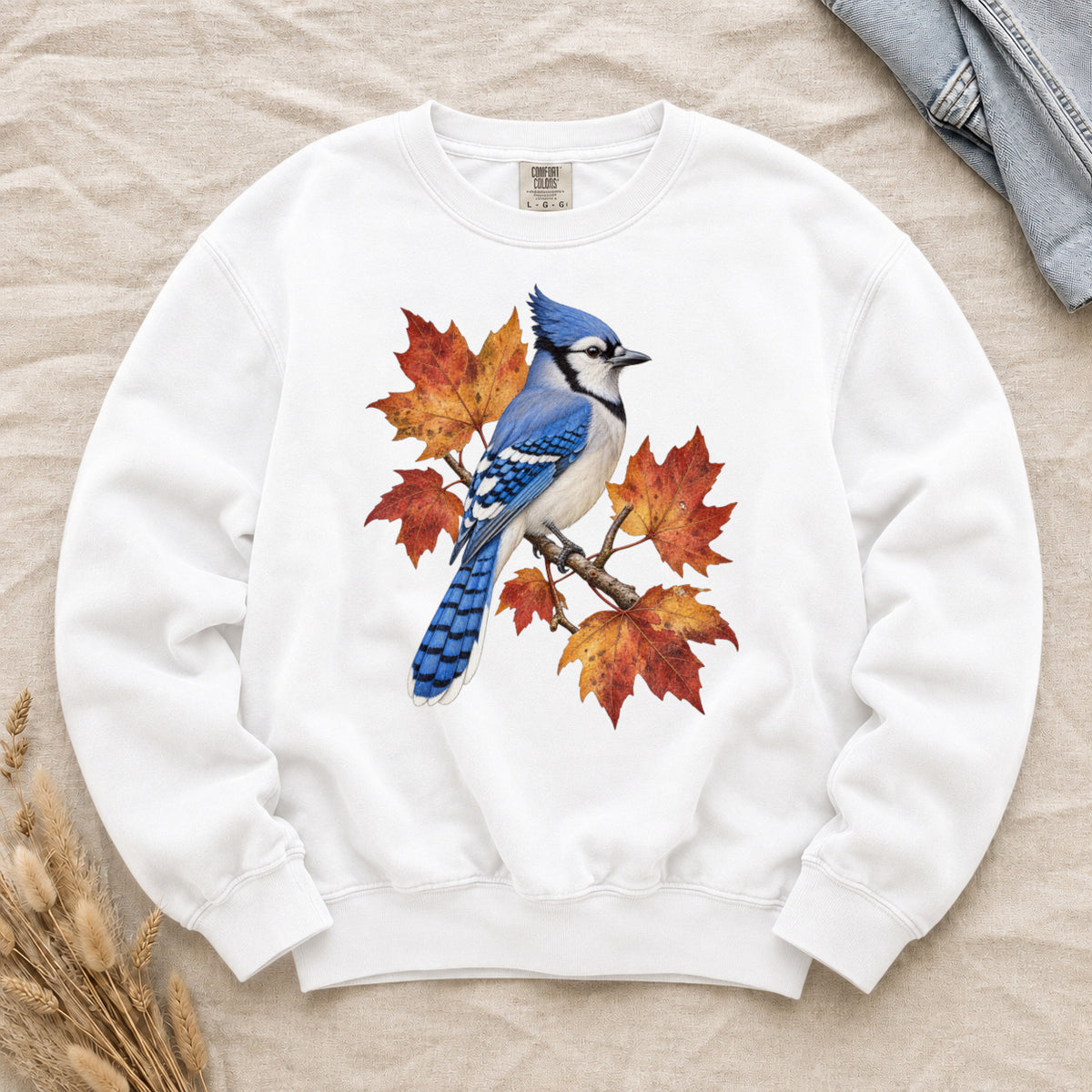 Autumn Has a Blue Note sweatshirt in White, a blue jay perched among amber, rust and red maple leaves