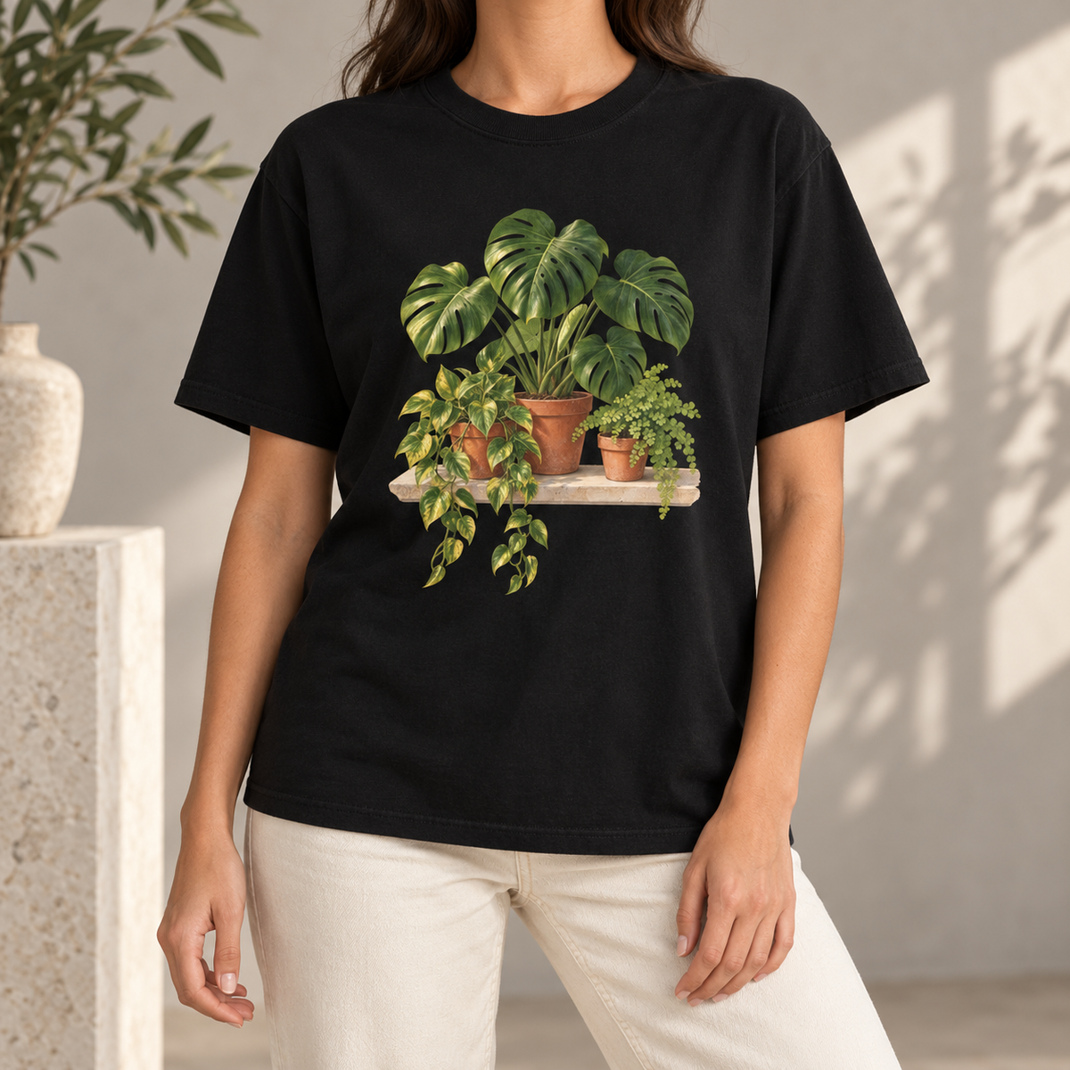 Houseplant t-shirt in Black worn by a woman – the trailing pothos and monstera print on the chest of a garment-dyed Comfort Colors tee