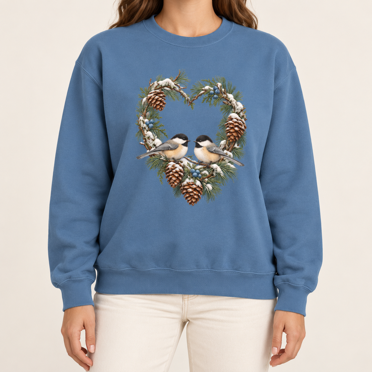 Chickadee heart wreath sweatshirt in Blue Jean – a pair of chickadees on a snowy pine heart wreath with pinecones, printed large on the chest of a Comfort Colors crewneck