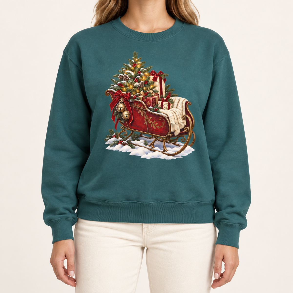 Vintage Christmas sleigh sweatshirt in Blue Spruce – a cranberry-red sleigh with gold trim heaped with fresh-cut fir and hung with golden bells, printed large on the chest of a Comfort Colors crewneck