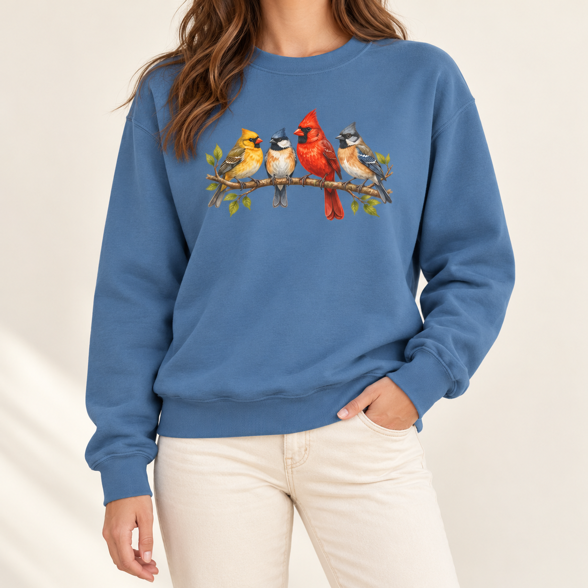 Four Colorful Songbirds on a Leafy Branch Sweatshirt in Blue Jean - a cardinal pair, a chickadee and a bluebird on one branch, printed on a garment-dyed Comfort Colors 1566 crewneck