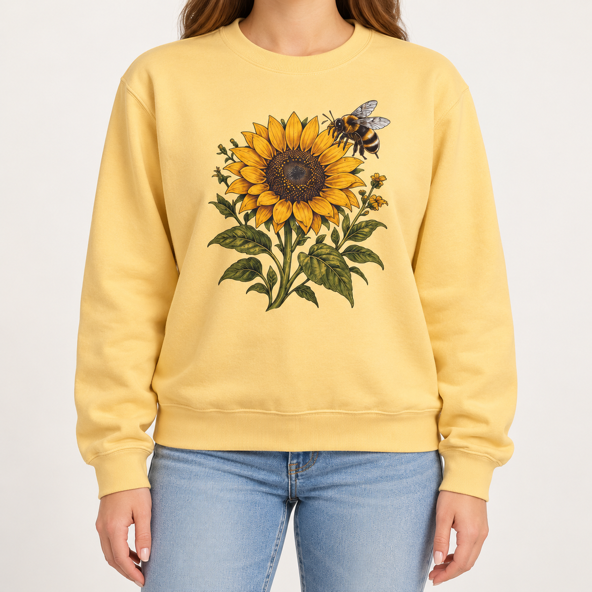 Sunflower and bumblebee sweatshirt in Butter: a golden sunflower with a hovering bumblebee and olive leaves, on a soft pale yellow garment-dyed Comfort Colors crewneck