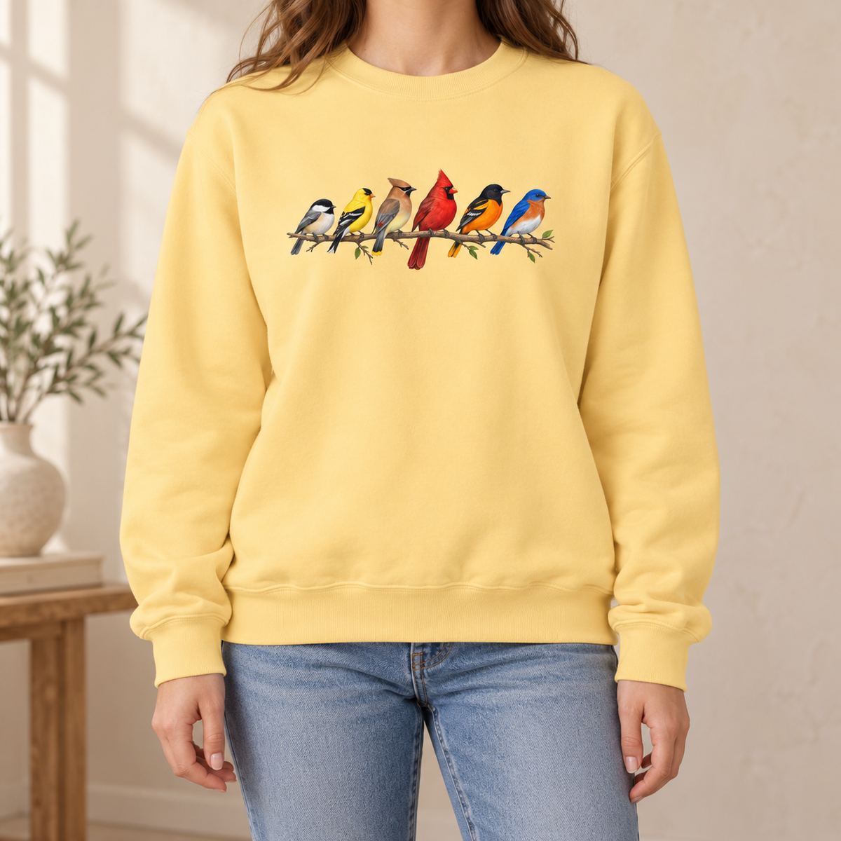 Colorful Birds on Branches sweatshirt in Butter — six painted songbirds on one branch: chickadee, goldfinch, cedar waxwing, northern cardinal, Baltimore oriole and eastern bluebird, on a garment-dyed Comfort Colors crewneck