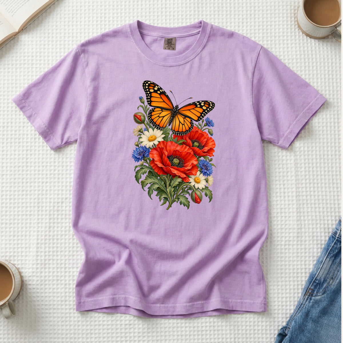 Red Poppies and Butterfly T-Shirt in Orchid — soft lilac, with an orange-and-black butterfly above red poppies and cream daisies