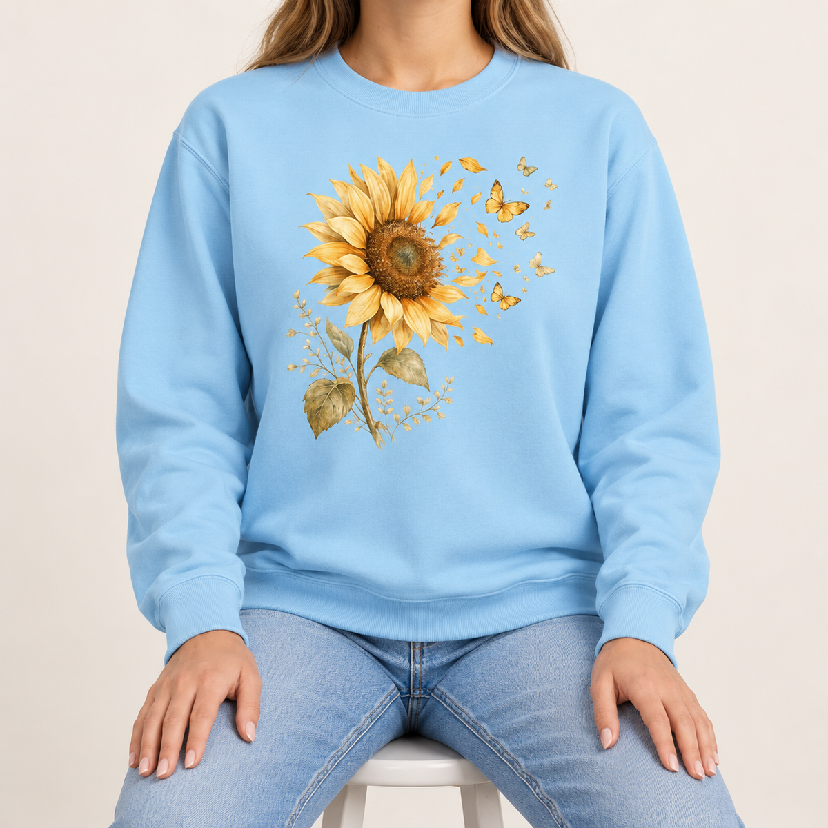 Sunflower butterfly sweatshirt in Chambray – a golden watercolor sunflower letting go of its petals as small gold butterflies, printed large on the chest of a Comfort Colors crewneck