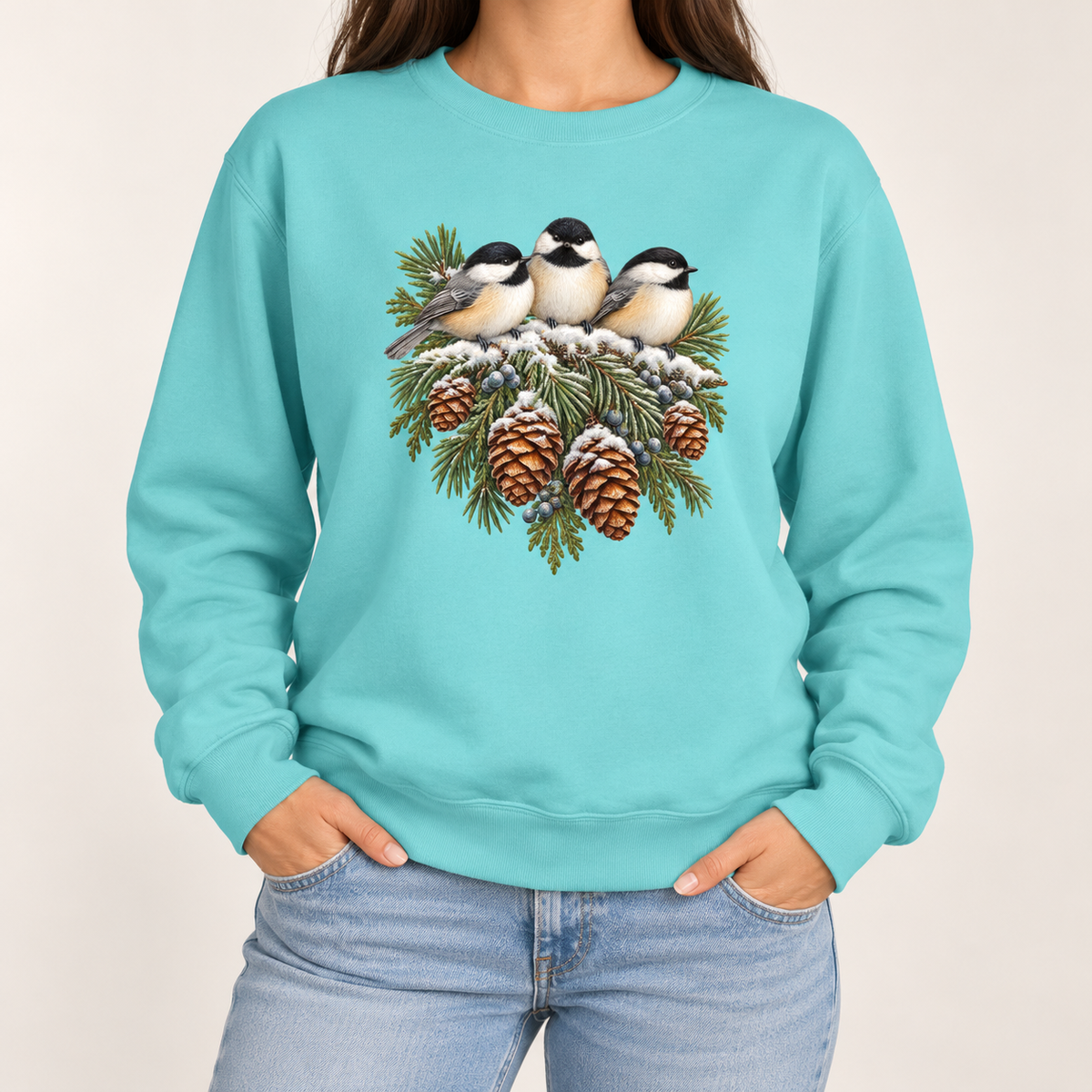 Three chickadees and snowy pinecones on a Chalky Mint garment-dyed Comfort Colors sweatshirt