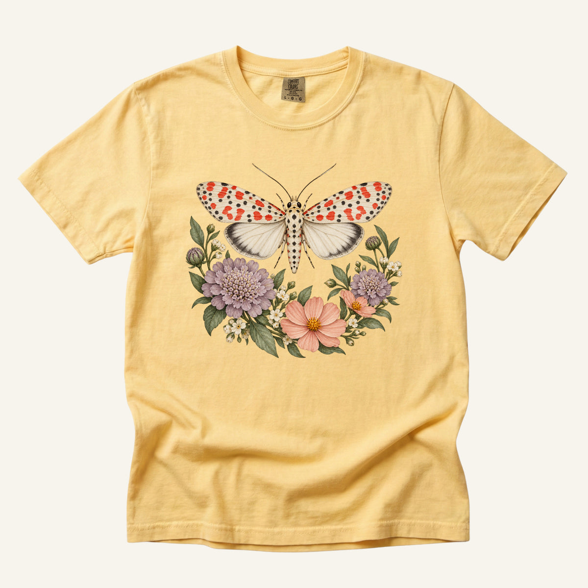 Moth T-Shirt in Butter — a crimson speckled moth among wildflowers on garment-dyed cotton