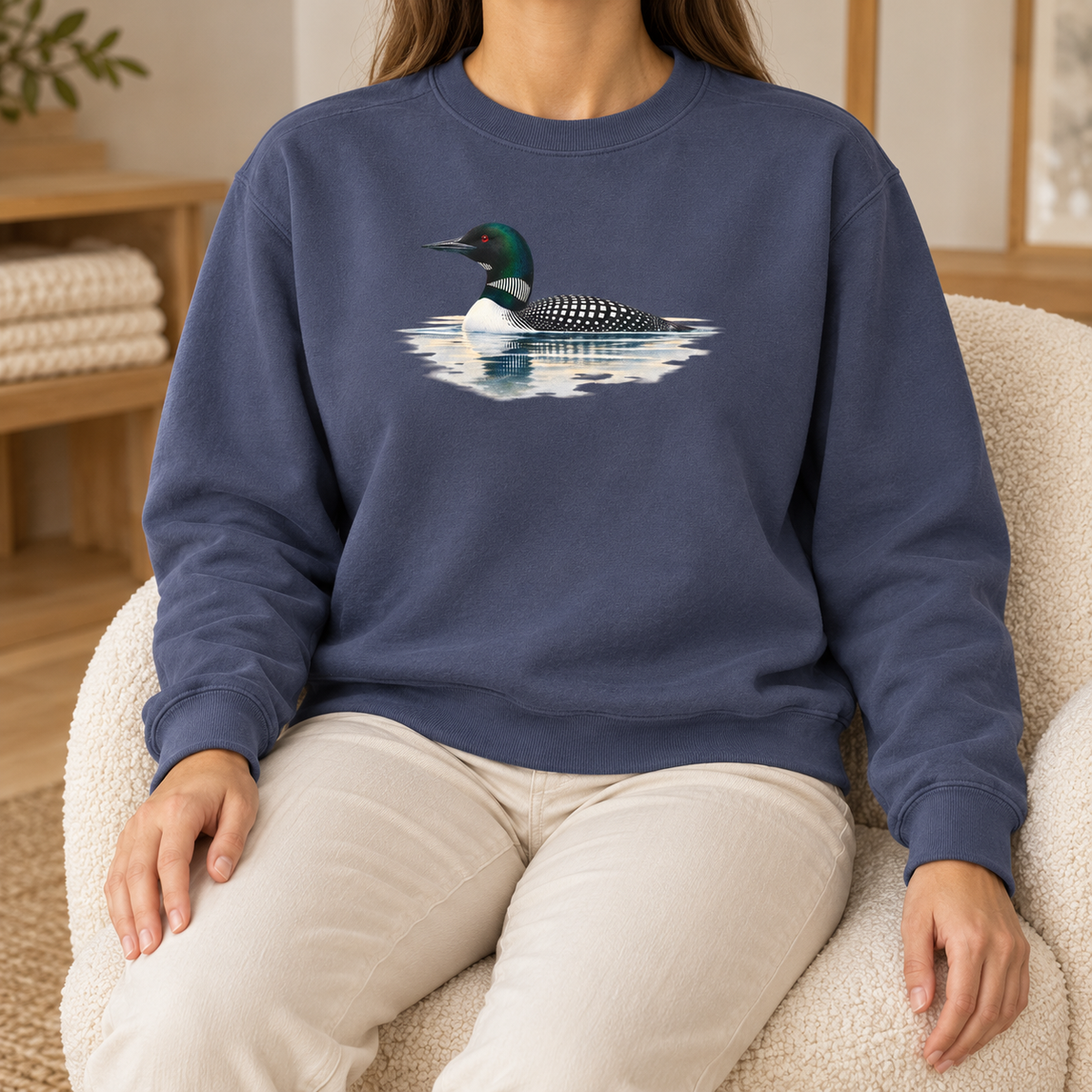 Common Loon Sweatshirt in Denim - watercolor loon on a misty lake printed on a dark washed blue Comfort Colors crewneck, worn by a woman