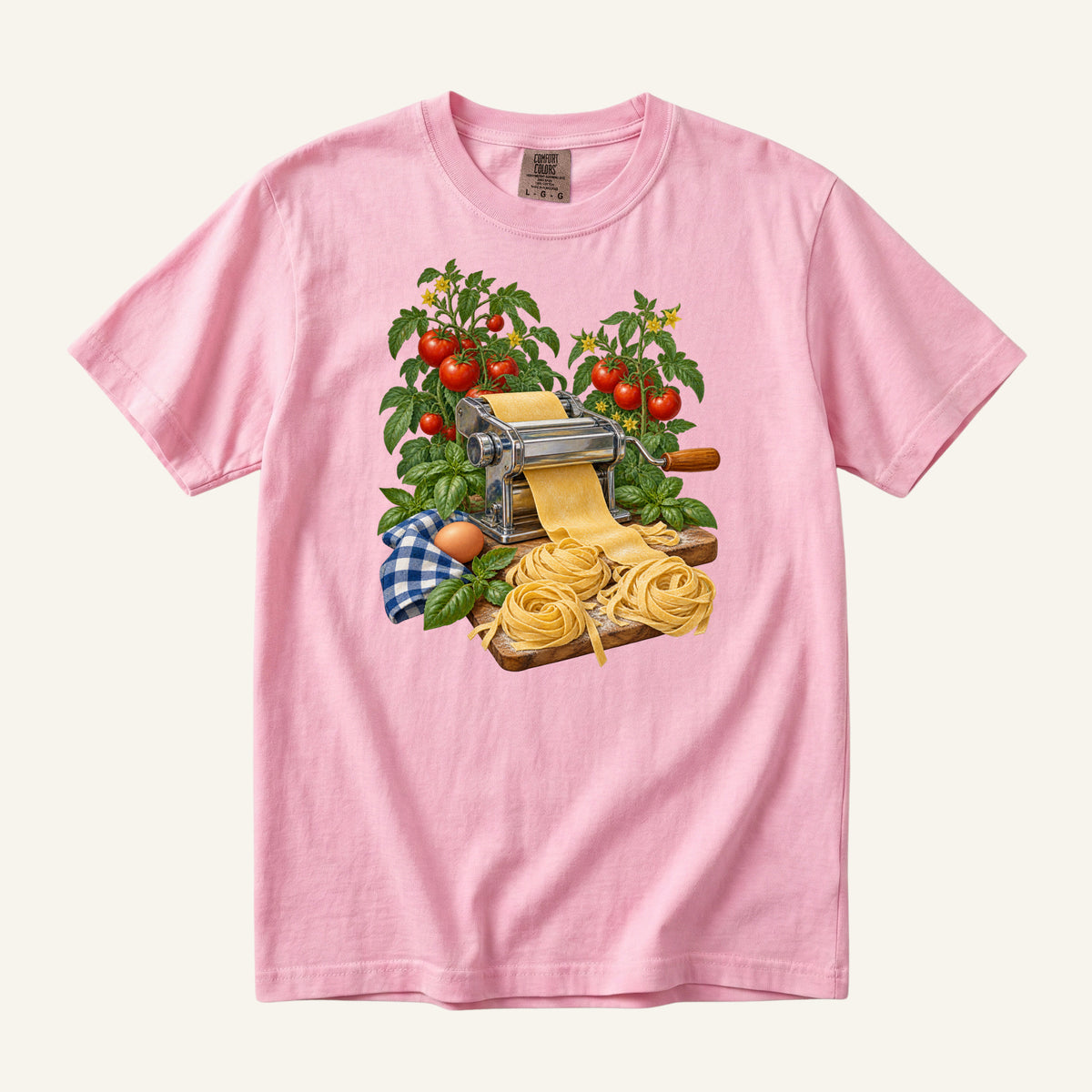 Dinner Takes a Little Longer handmade pasta t-shirt in Blossom, a pale soft pink — vintage pasta machine with fresh pasta, tomatoes and basil, garment-dyed Comfort Colors 1717 tee
