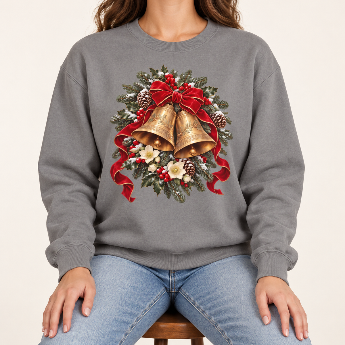 Vintage Christmas bells sweatshirt in Grey – two golden bells with a red velvet bow among snowy pine, holly, pinecones and hellebores, printed large on the chest of a Comfort Colors crewneck