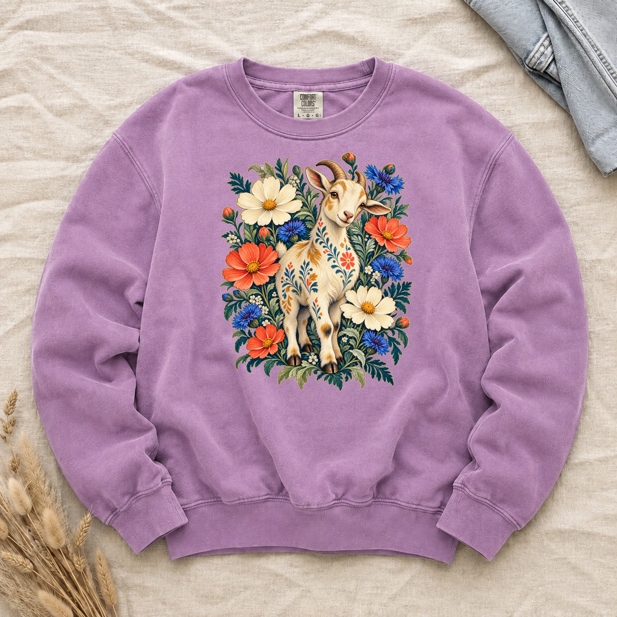 Folk-art goat patterned with flowers among coral and blue blooms on an Orchid lilac Comfort Colors crewneck sweatshirt
