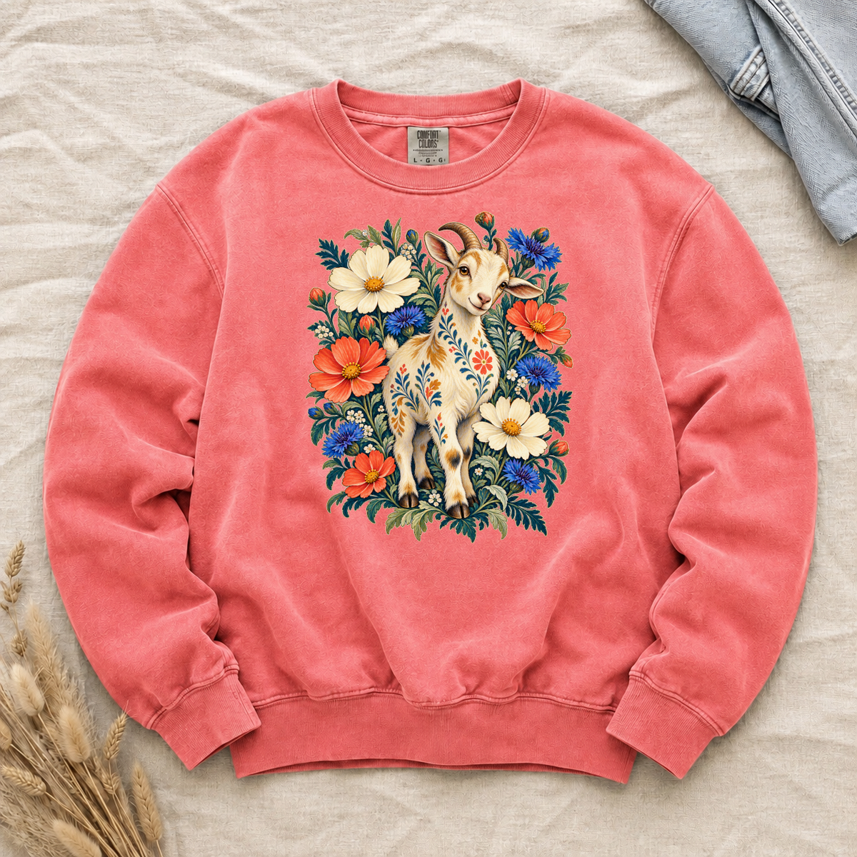 Folk-art goat patterned with flowers among coral and blue blooms on a Watermelon pink Comfort Colors crewneck sweatshirt
