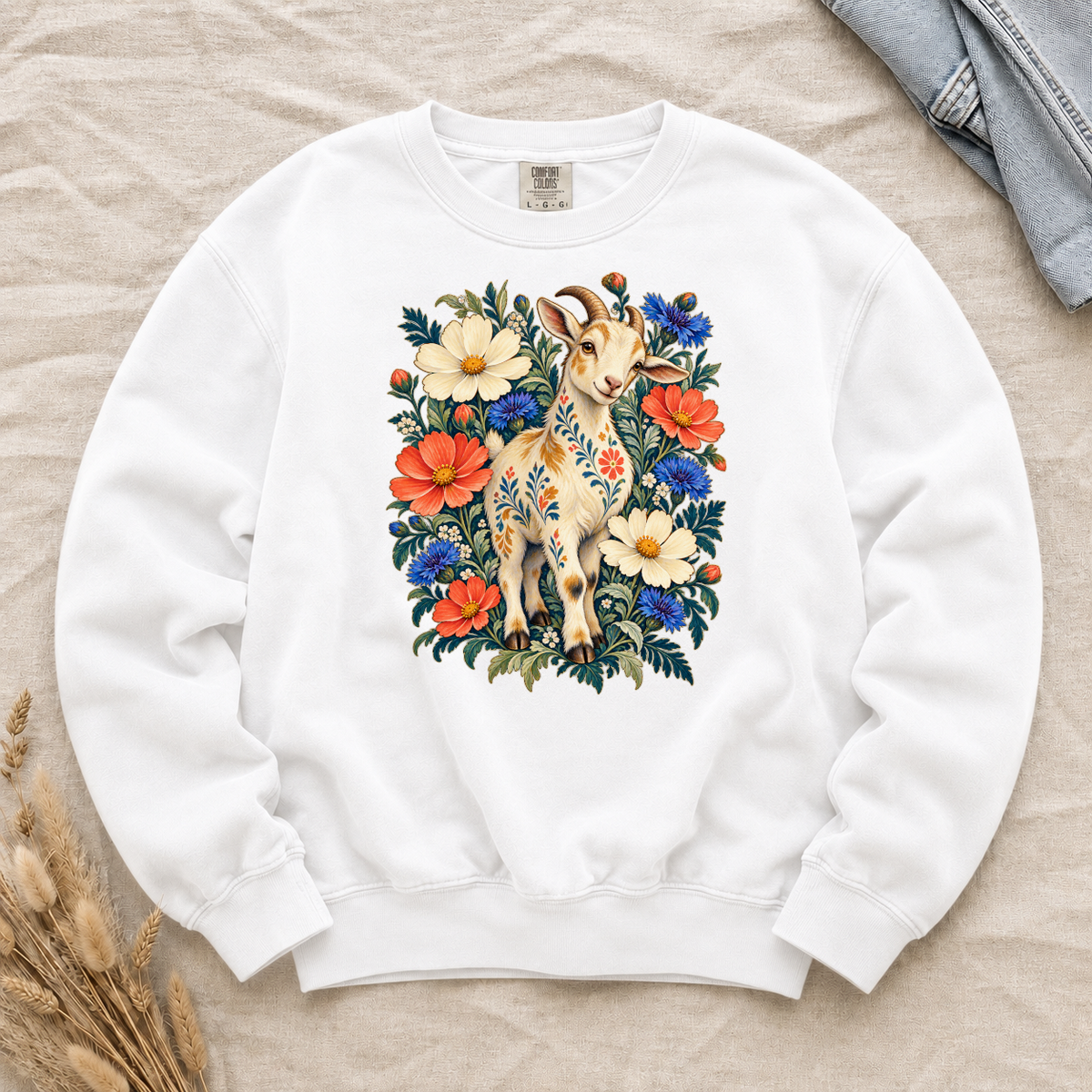Folk-art goat patterned with flowers among coral and blue blooms on a White Comfort Colors crewneck sweatshirt