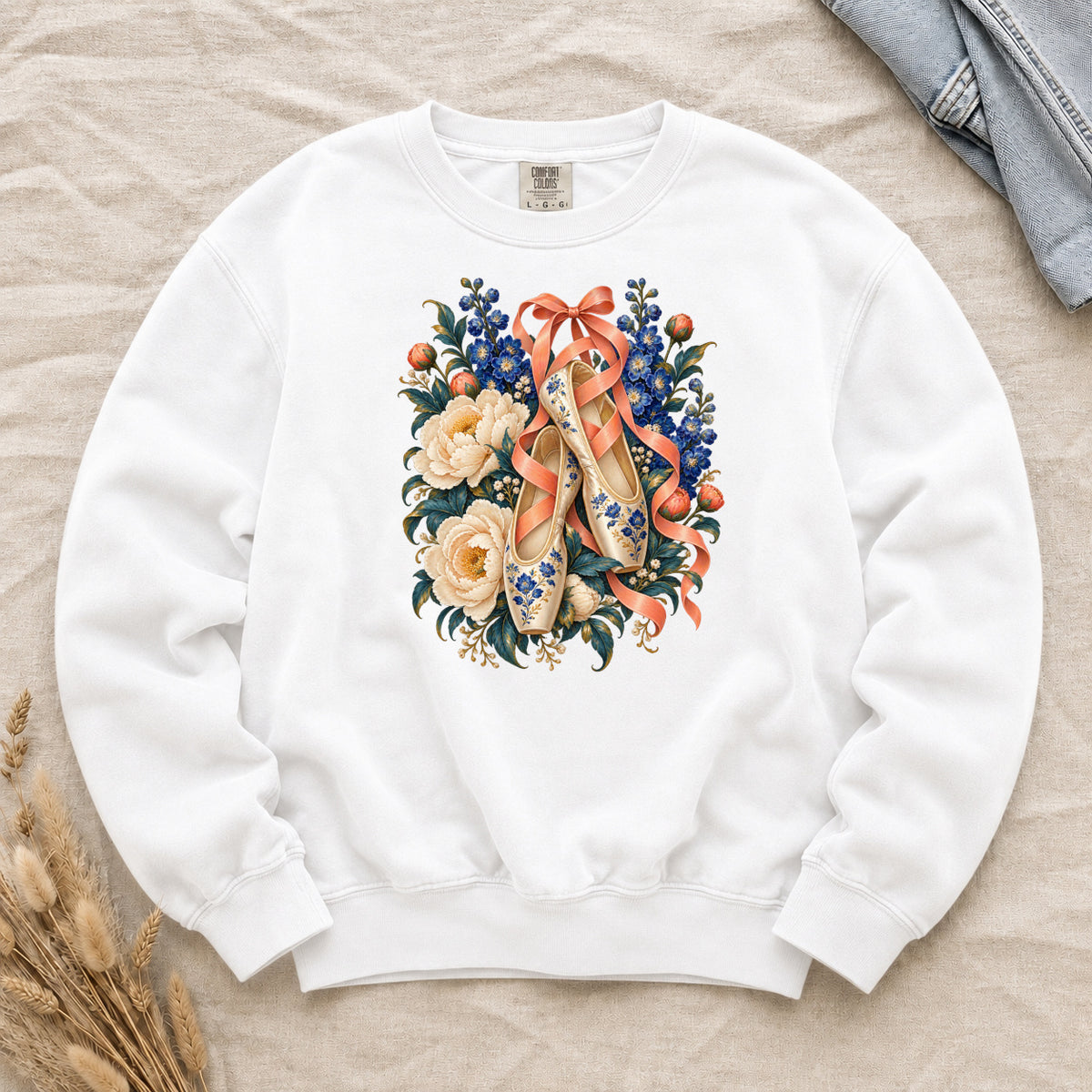 Floral Ballet Slippers Sweatshirt in White — cream ballet slippers with blue-and-gold ornament hanging from coral ribbons among ivory roses