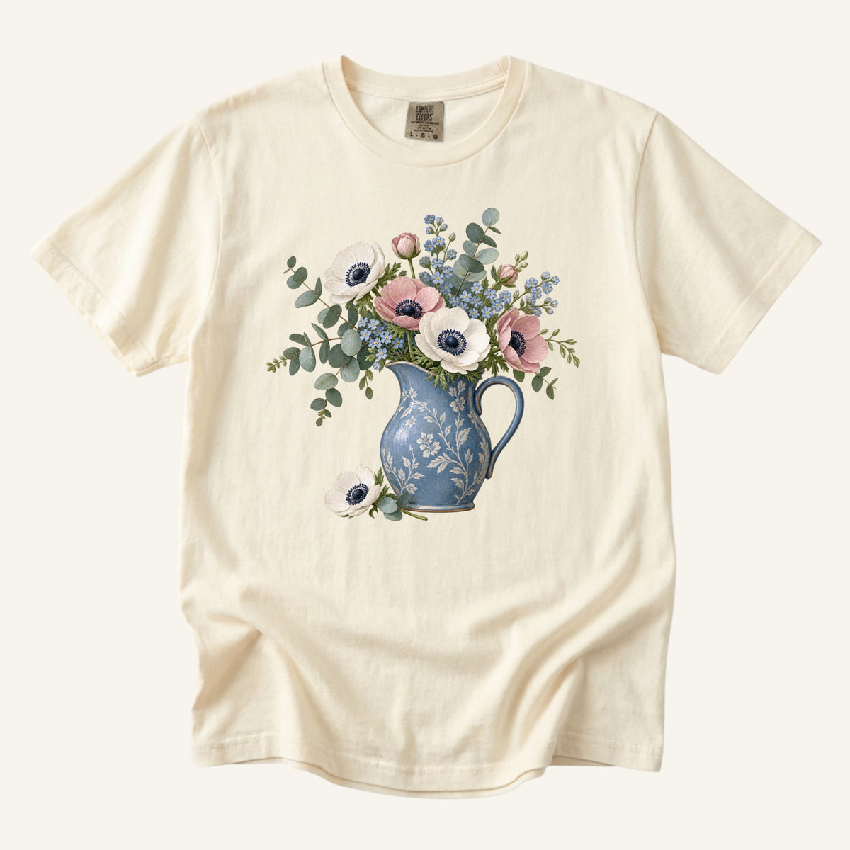 Floral Blue Pitcher T-Shirt in Ivory — a vintage blue pitcher of blush and cream anemones with one bloom laid beside it