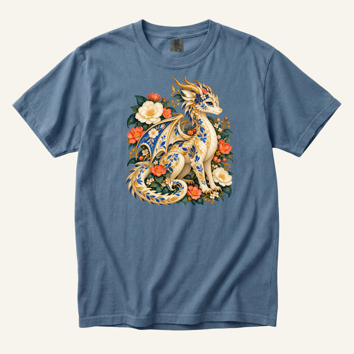 The Garden Was Her Gold floral dragon t-shirt in Blue Jean, a cream-and-gold dragon patterned with blue botanical ornament like painted porcelain, seated among coral-red flowers, ivory blossoms and deep green foliage