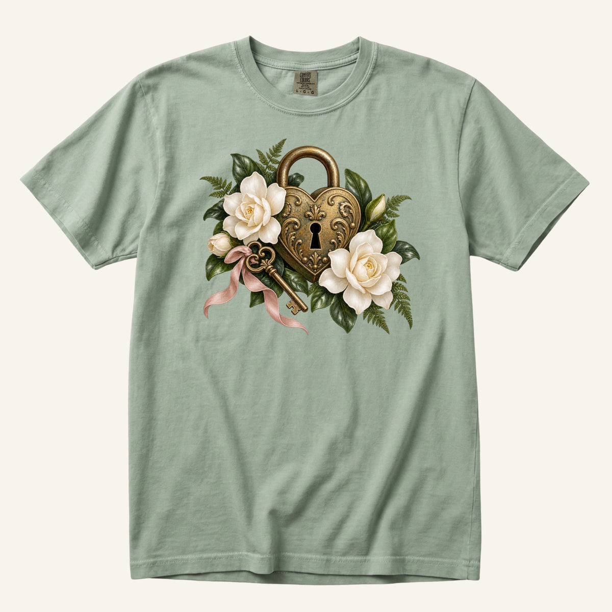 Floral Heart Lock & Key T-Shirt in Bay — an antique heart padlock and decorative key among cream blossoms, ferns and a dusty pink ribbon