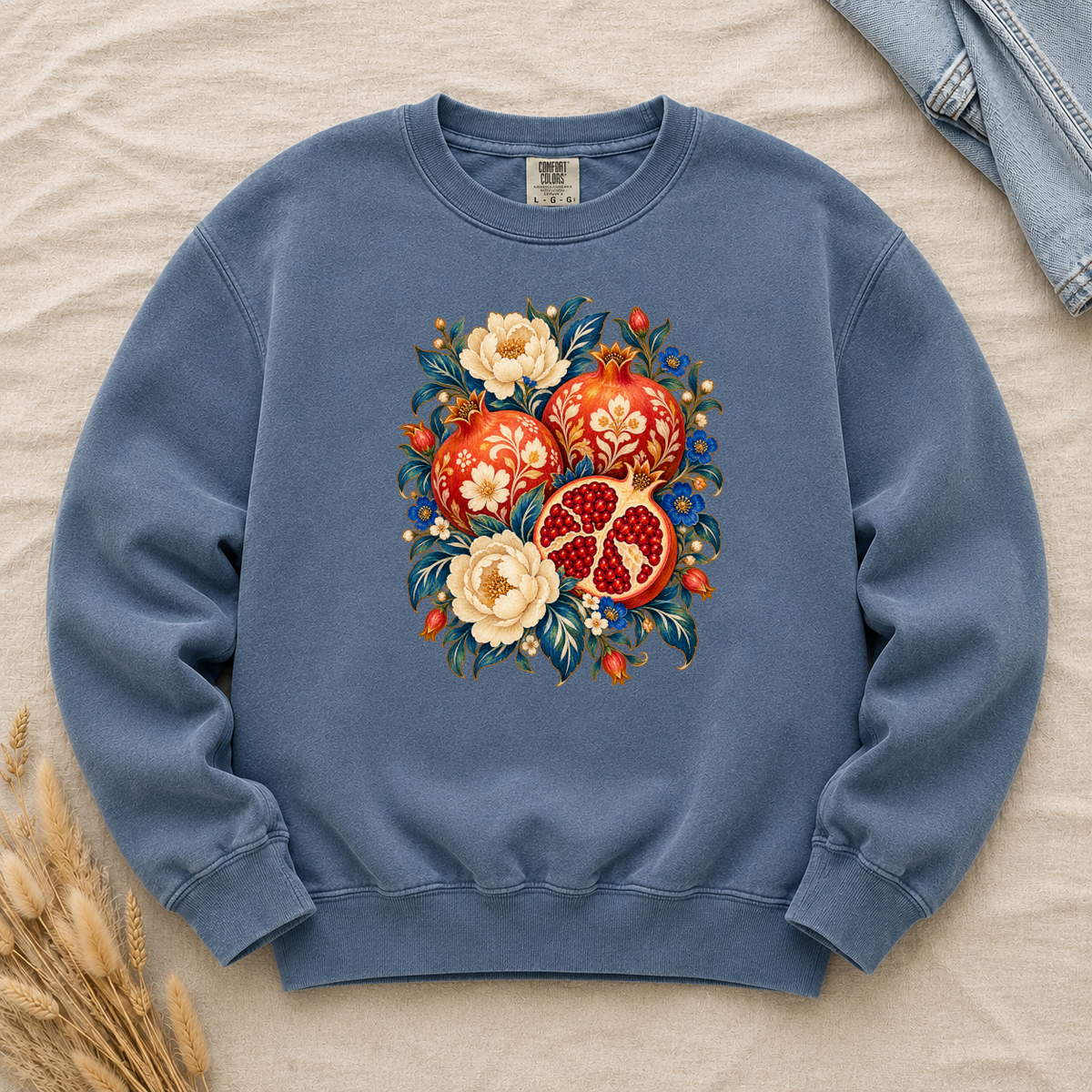 Folk-art pomegranates and cream blossoms printed on a Denim blue Comfort Colors crewneck sweatshirt
