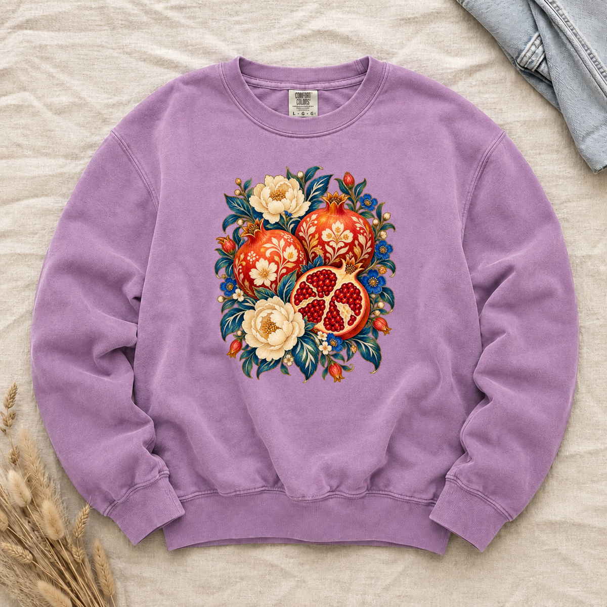 Folk-art pomegranates and cream blossoms printed on an Orchid lilac Comfort Colors crewneck sweatshirt