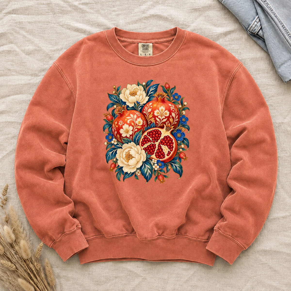 Folk-art pomegranates and cream blossoms printed on a Terracotta Comfort Colors crewneck sweatshirt