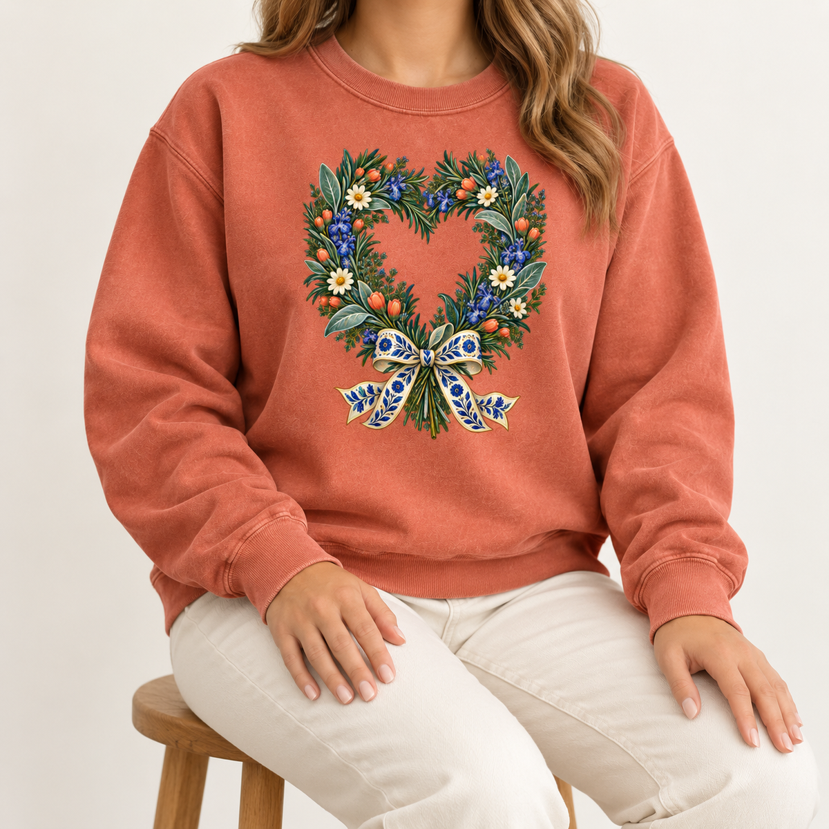 Cream daisies and warm red-orange berries dotted along the branches of the heart wreath