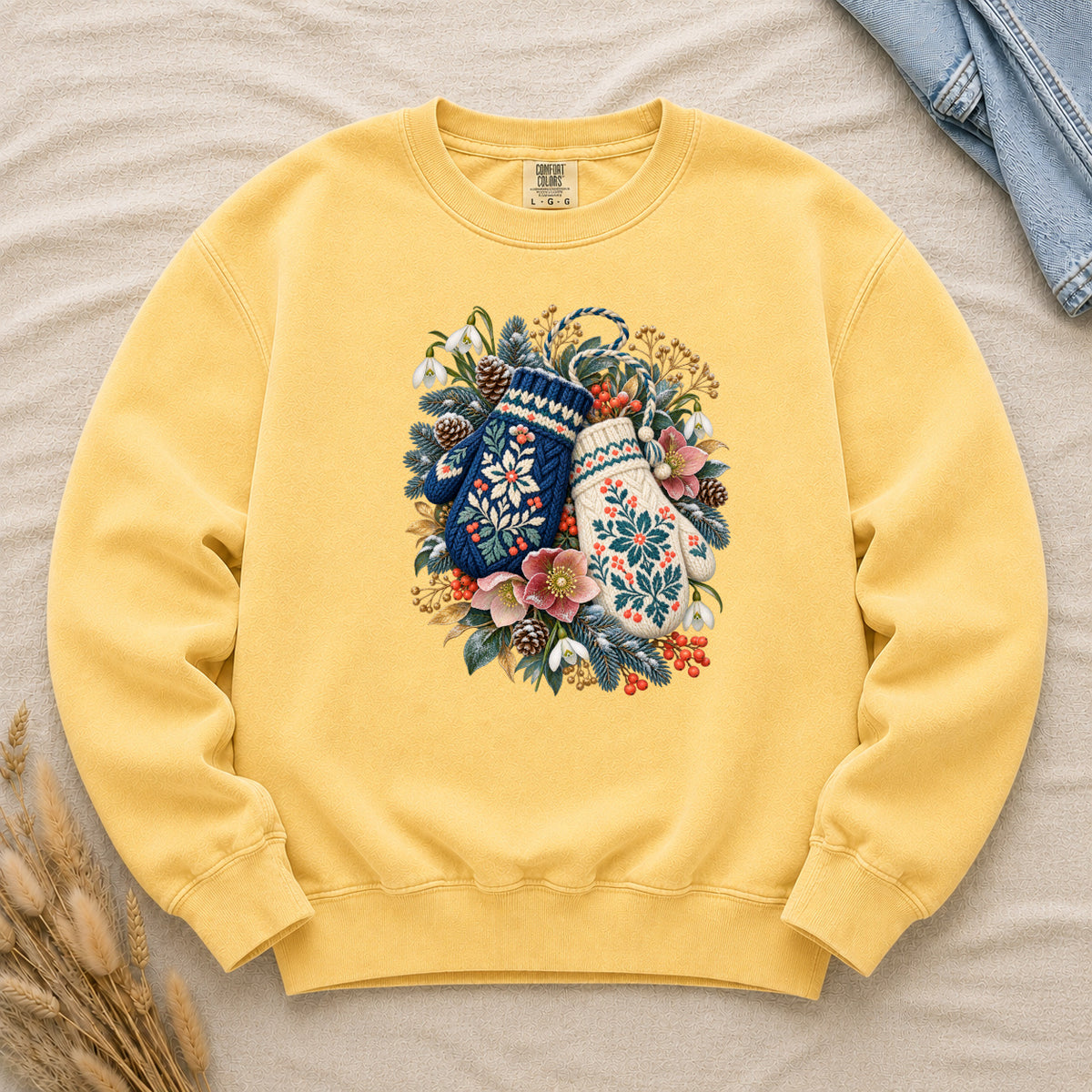 Floral Winter Mittens Sweatshirt in Butter — soft warm cream, with a deep navy and a cream mitten in a winter bouquet of evergreen, pinecones and berries