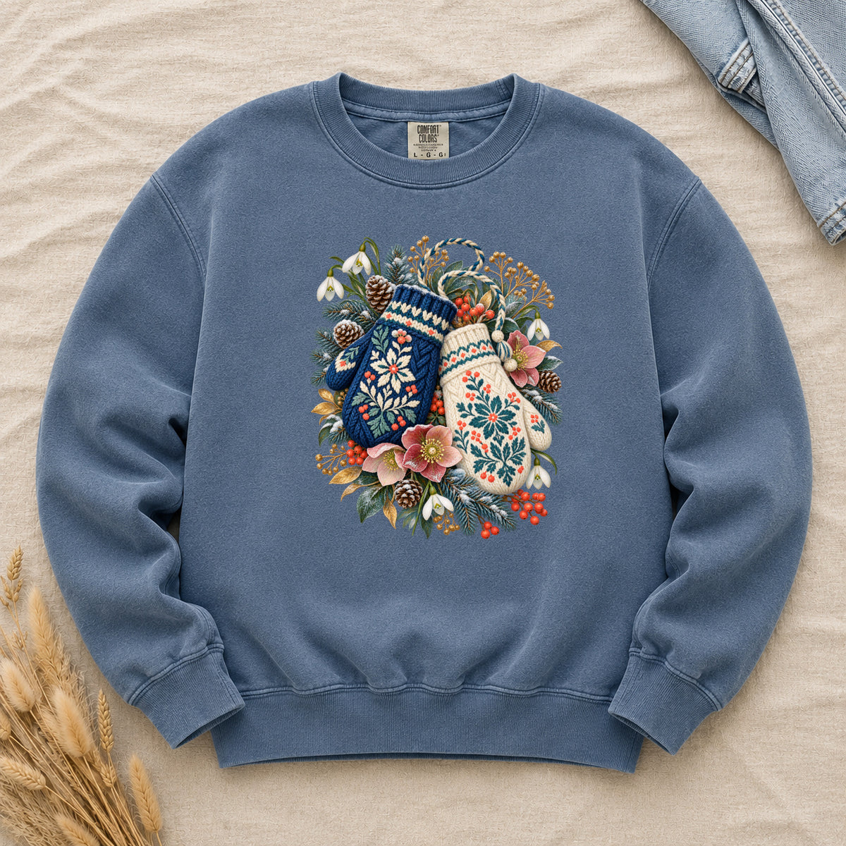 Floral Winter Mittens Sweatshirt in Denim — washed mid-blue, with a deep navy and a cream mitten in a winter bouquet of evergreen, pinecones and berries