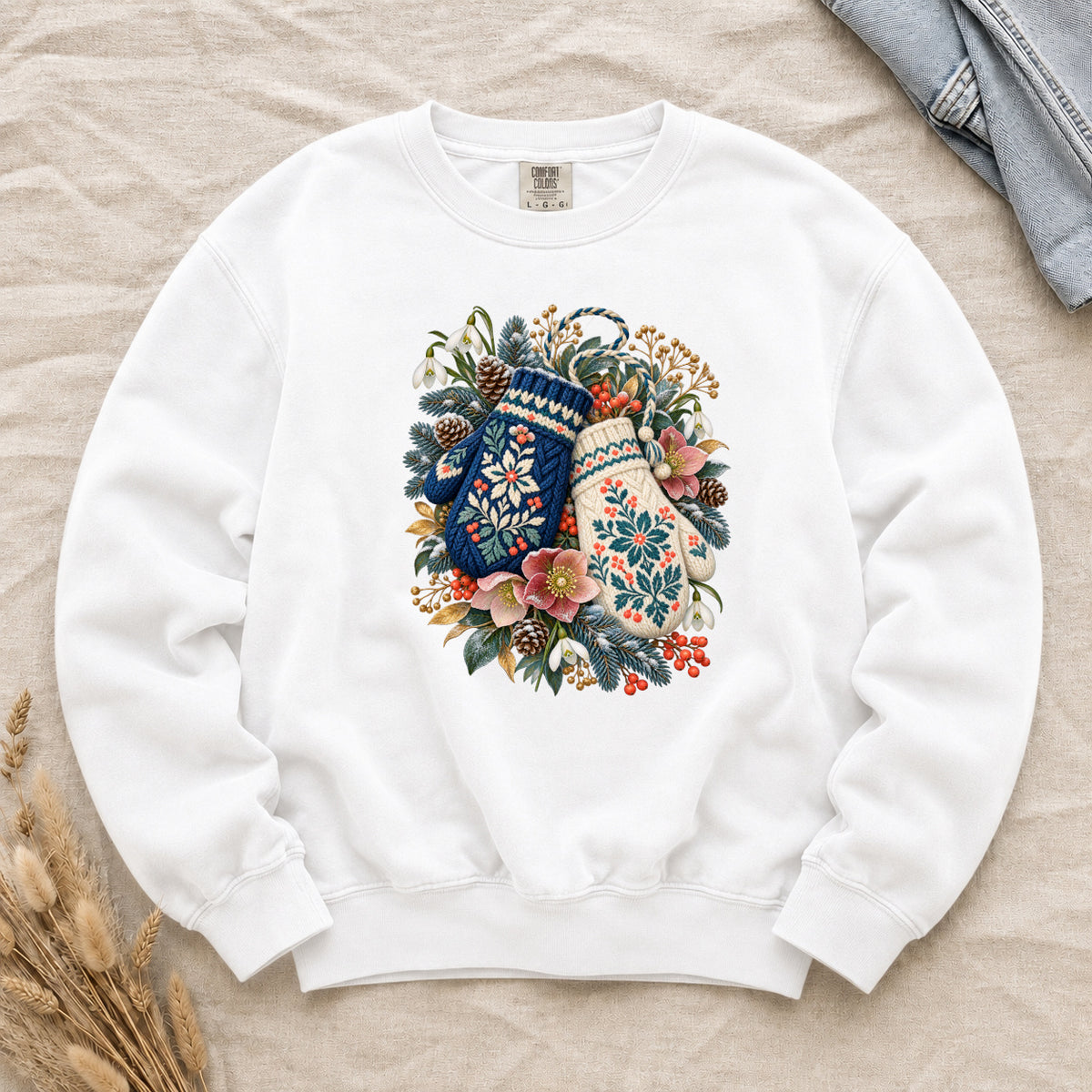 Floral Winter Mittens Sweatshirt in White — the clearest colorway, with a deep navy and a cream mitten in a winter bouquet of evergreen, pinecones and berries