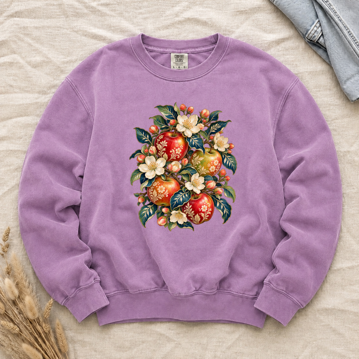 Folk-art apples and cream blossoms printed on an Orchid lilac Comfort Colors crewneck sweatshirt