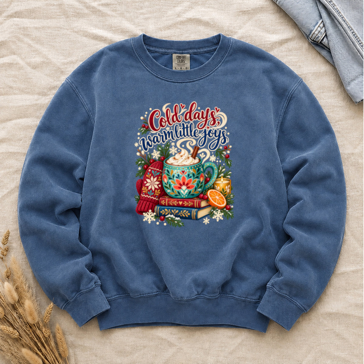 Cocoa and books winter sweatshirt in Blue Jean, a light washed blue garment-dyed Comfort Colors crewneck with the cozy winter still life printed on the chest