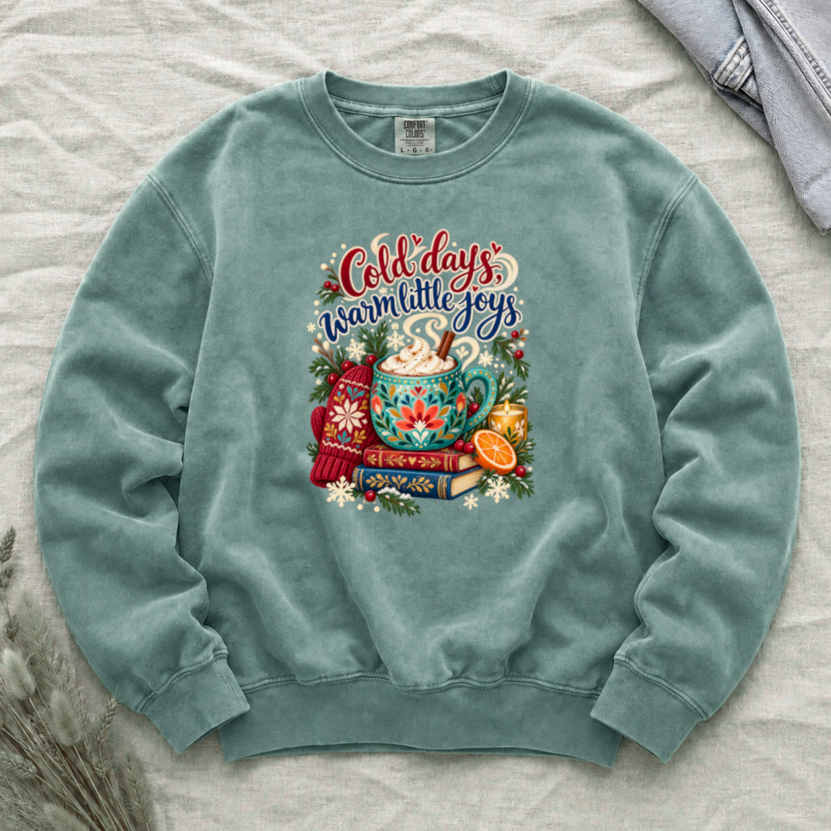 Cocoa and books winter sweatshirt in Light Green, a soft sage garment-dyed Comfort Colors crewneck with the cozy winter still life printed on the chest