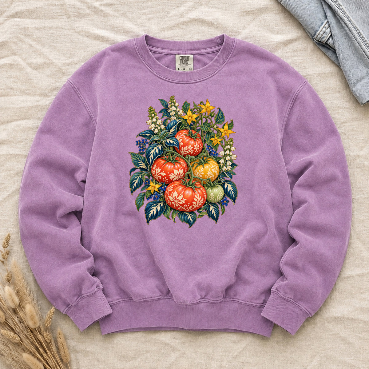 Folk-art tomatoes on the vine with cream patterning printed on an Orchid lilac Comfort Colors crewneck sweatshirt