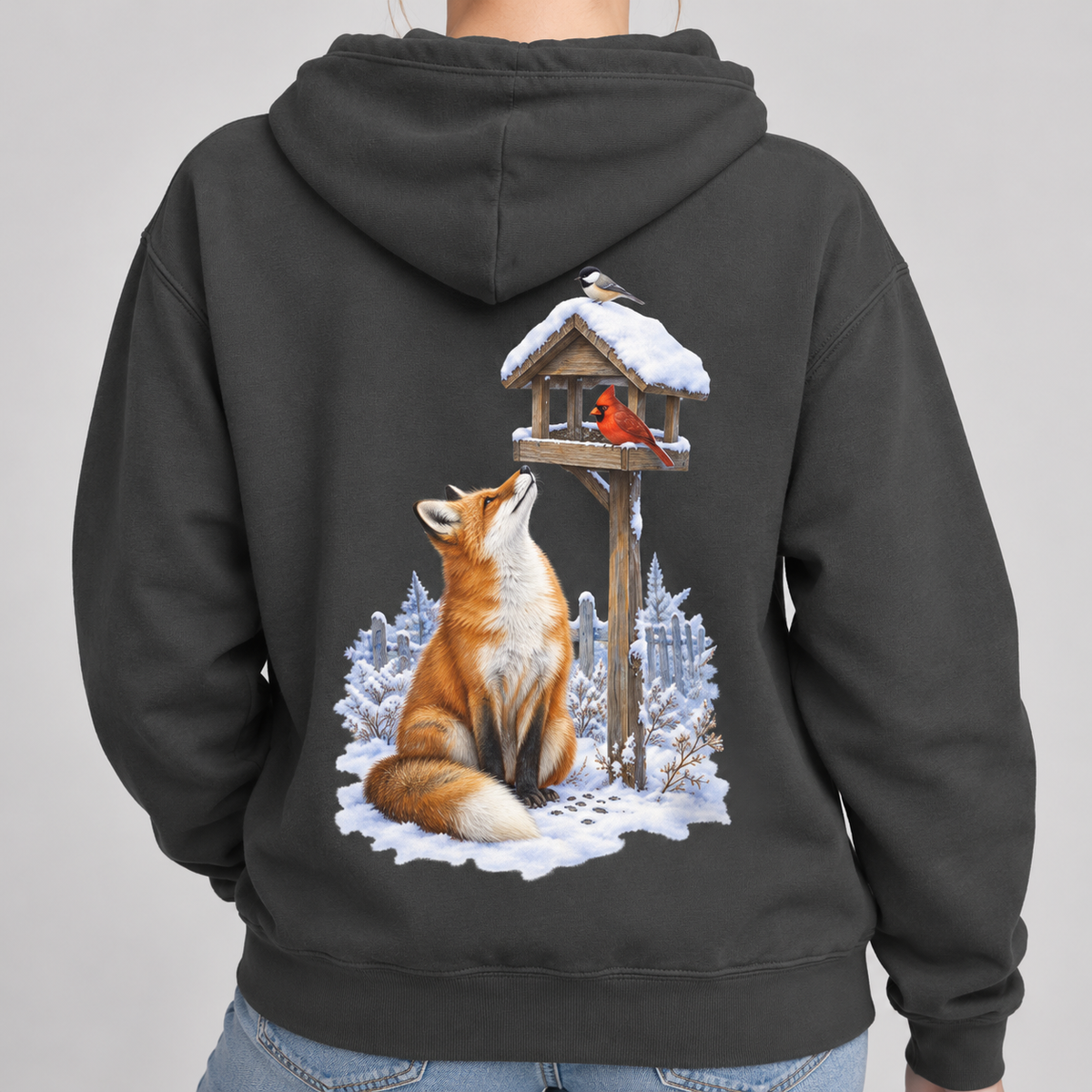 Beneath the Feeder hoodie, close view of the back print: red fox beneath a cardinal on a snowy feeder