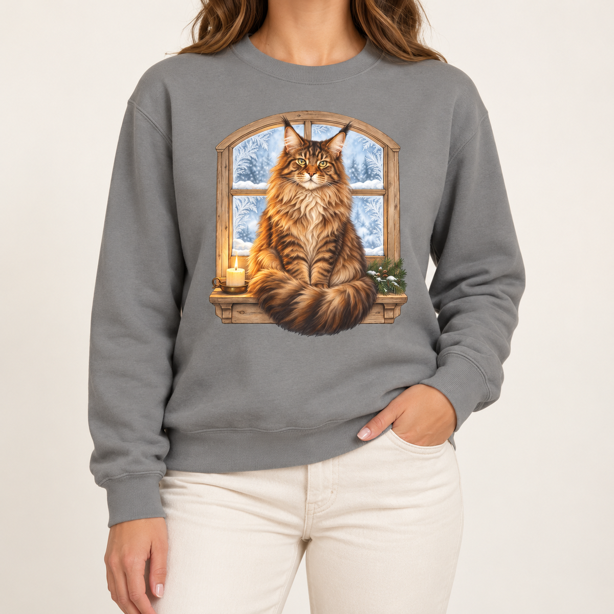 Maine Coon at the window sweatshirt in Grey – a tabby Maine Coon on a frosted windowsill with a candle and pine, snowy forest through an arched window, printed large on the chest of a Comfort Colors crewneck