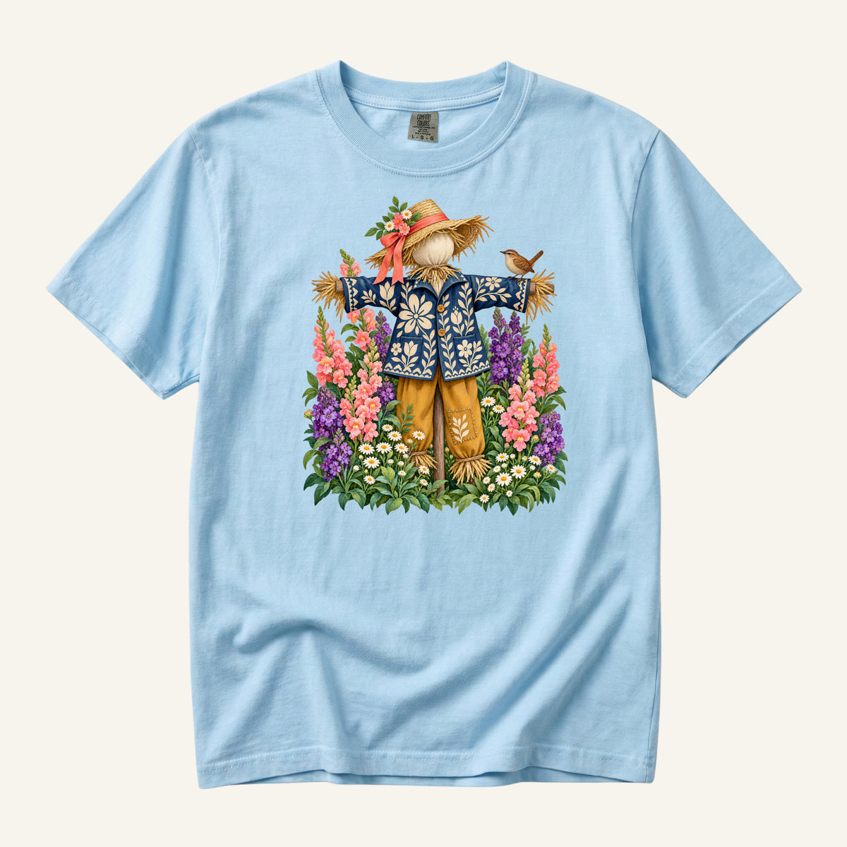 He Let Them Stay T-Shirt in Chambray — a light backdrop keeping the foliage distinct behind the deep blue jacket