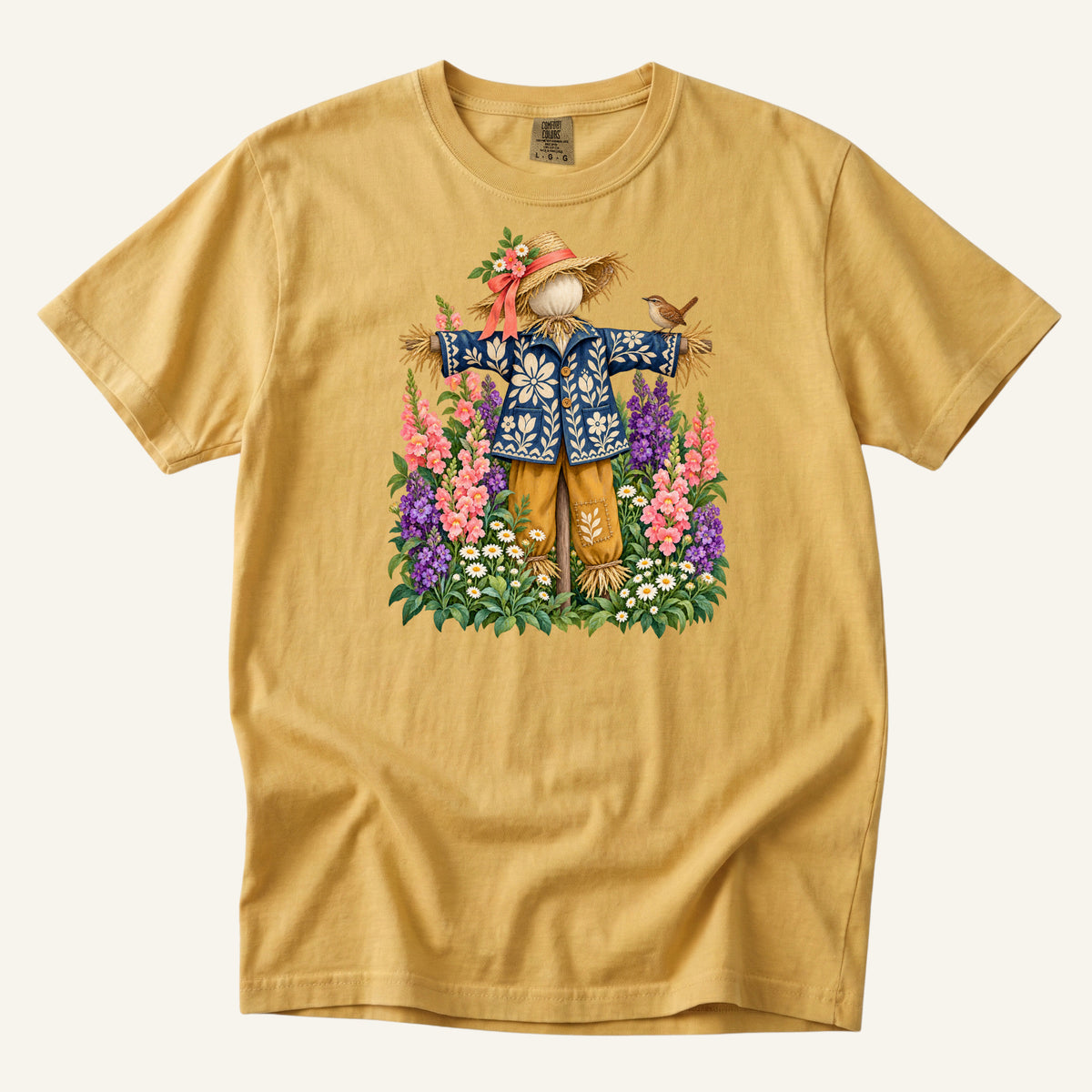 He Let Them Stay T-Shirt in Mustard — a warm harvest gold echoing the scarecrow's straw hat and golden trousers